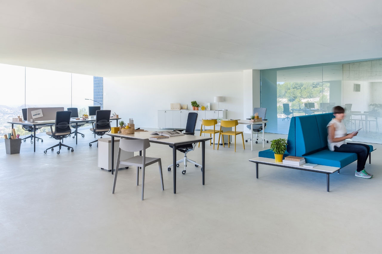 siva podlaha z liateho betonu a moderny farebny nabytok v kancelarii